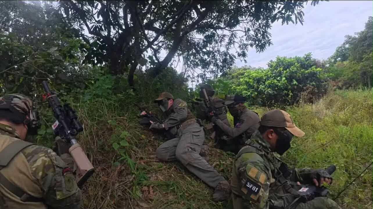 A squad works the edge of a grassy slope during an active field scenario