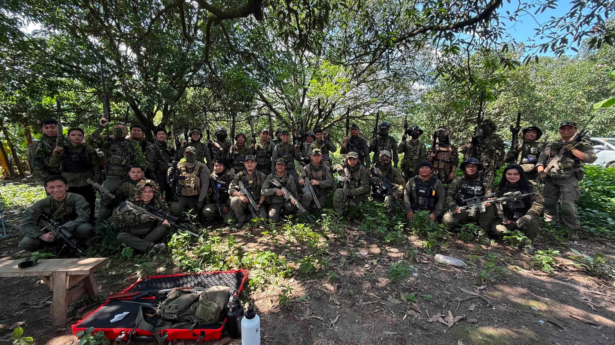 Members gather under tree cover between rounds.