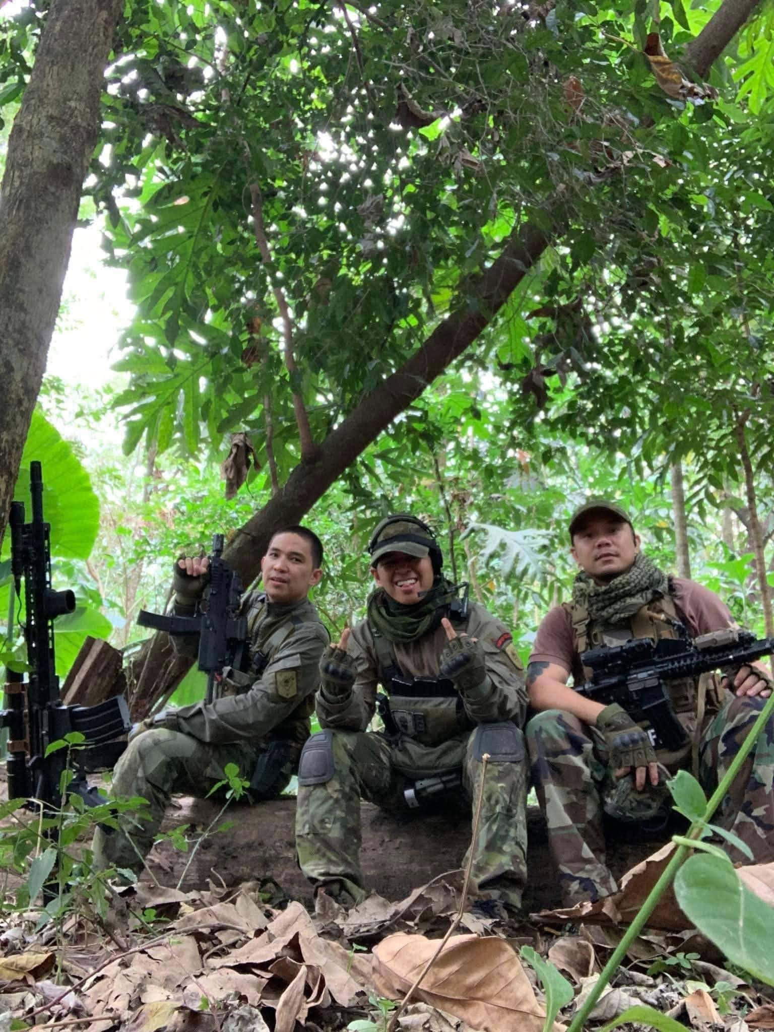 Three members share a light moment under the jungle canopy.