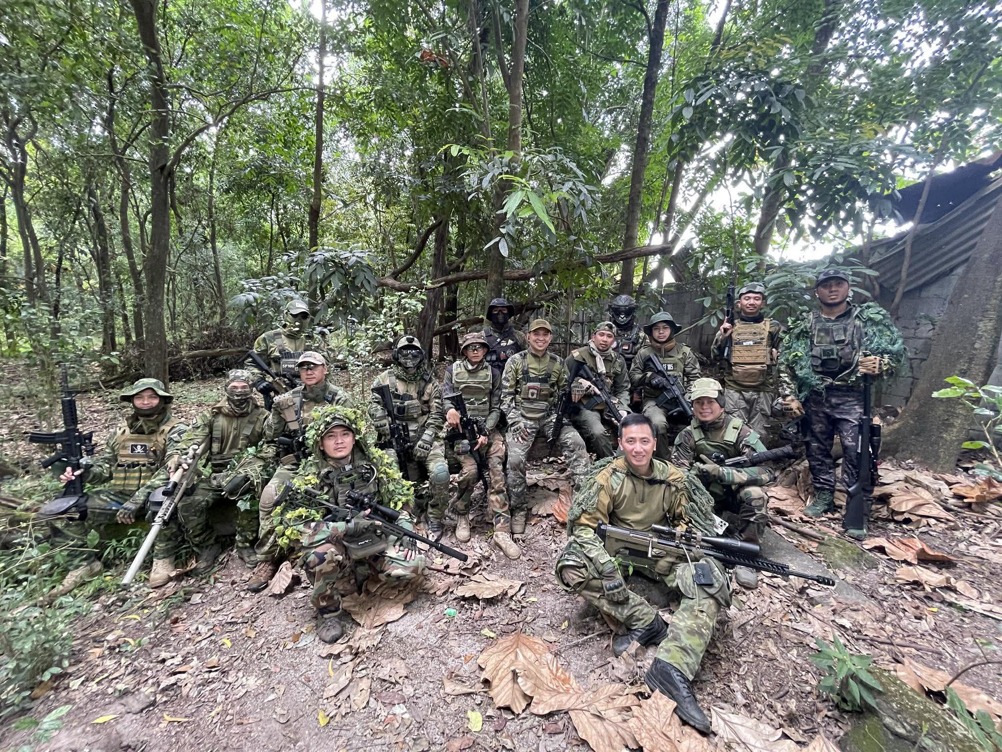 A squad with long-range rifles gathers on a wooded trail.