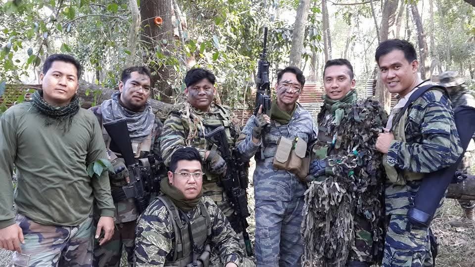 A squad in mixed camouflage patterns pauses in the field.